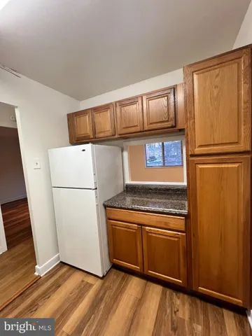 a kitchen with a refrigerator a stove top oven and cabinets