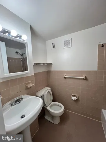 a bathroom with a sink a toilet and mirror