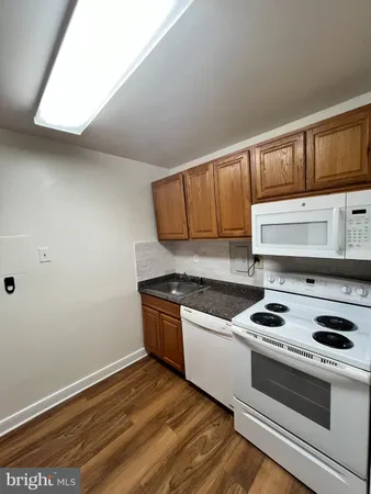 a kitchen with granite countertop a stove and a wooden cabinets