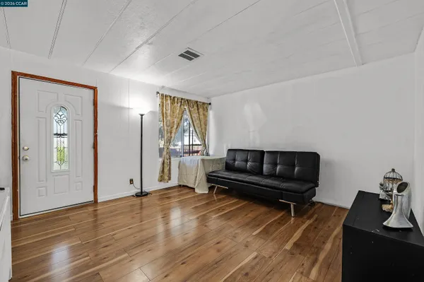 a living room with furniture and a wooden floor