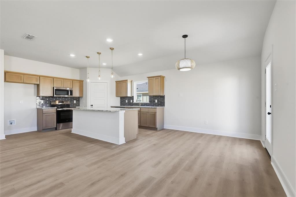 472 Peace Lily Way Tolar, TX 76476 - Photo 14 of 40 a large kitchen with granite countertop a large counter top a sink stainless steel appliances and cabinets