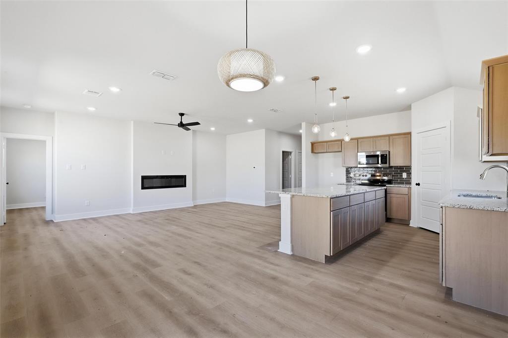 472 Peace Lily Way Tolar, TX 76476 - Photo 15 of 40 a kitchen with kitchen island white cabinets and refrigerator