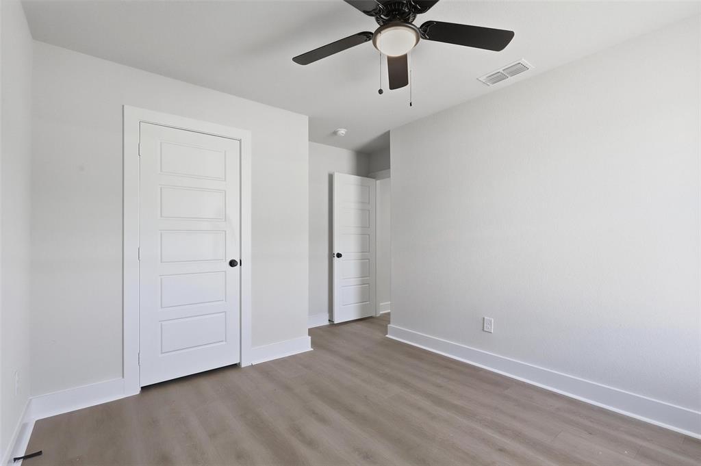 472 Peace Lily Way Tolar, TX 76476 - Photo 31 of 40 an empty room with a ceiling fan and wooden floor