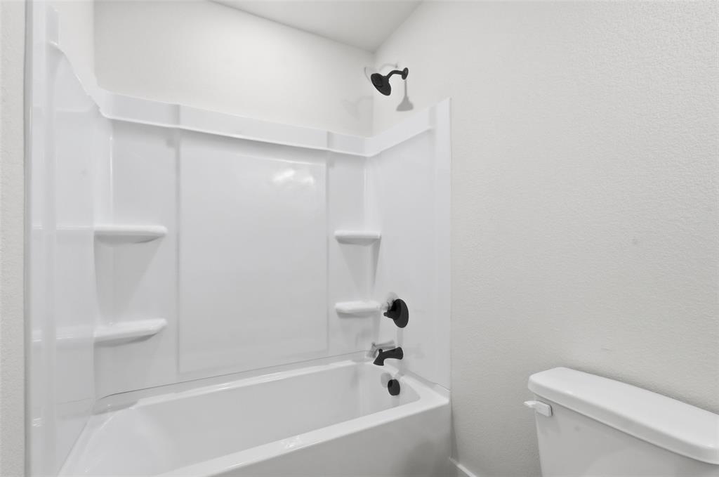 472 Peace Lily Way Tolar, TX 76476 - Photo 33 of 40 a bathroom with a bathtub and a toilet