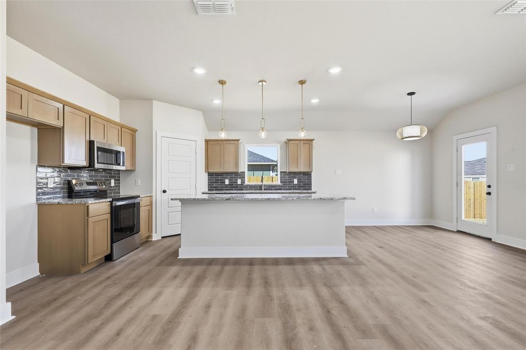 472 Peace Lily Way Tolar, TX 76476 - Photo 7 of 40 a view of kitchen with stainless steel appliances kitchen island wooden cabinets and granite counter tops
