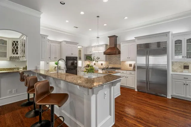 a kitchen with stainless steel appliances granite countertop a stove refrigerator and cabinets