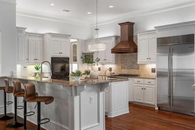 a kitchen with kitchen island granite countertop a sink cabinets and stainless steel appliances