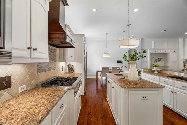 a kitchen with stove a sink and cabinets