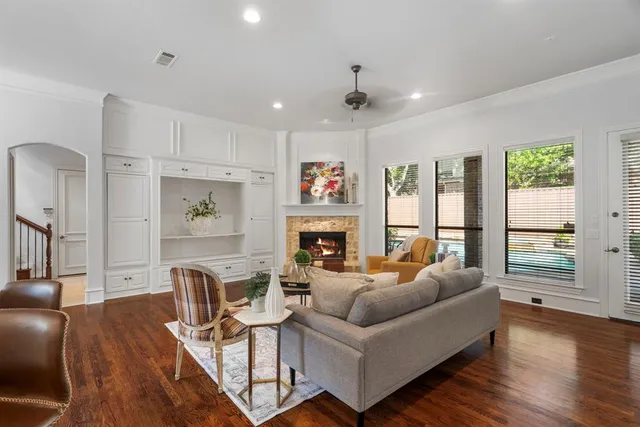 a living room with furniture large window and wooden floor
