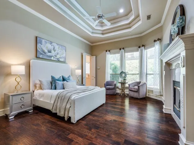 a spacious bedroom with a bed couch and a large window with wooden floor