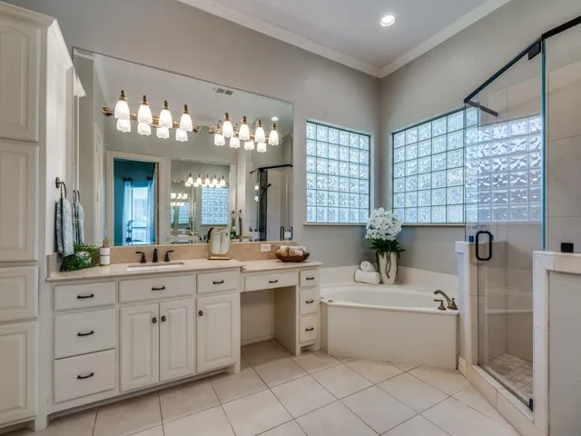 a bathroom with a double vanity sink mirror and bathtub