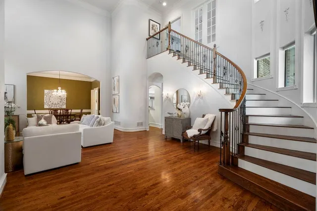 a living room with couches and a dining table with wooden floor