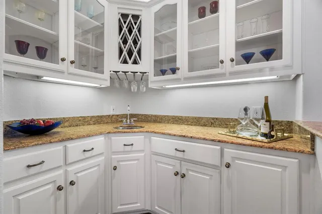 a kitchen with stainless steel appliances granite countertop white cabinets and a sink