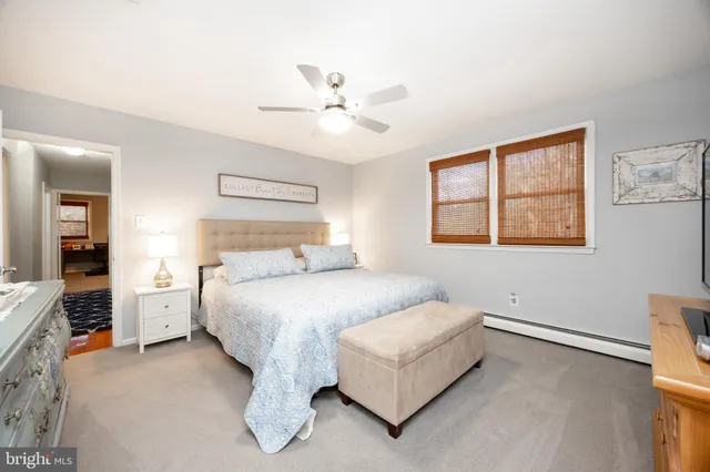 a view of a patio with a table and chairs under an umbrella with large trees