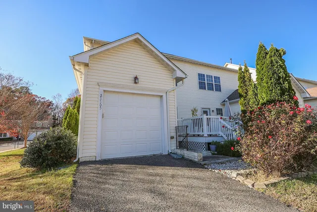 a view of a house with a small yard and flower plants