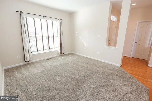 a view of a livingroom with wooden floor and a chandelier