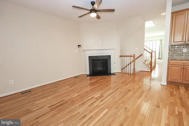 a large kitchen with stainless steel appliances granite countertop a stove a sink dishwasher and a refrigerator with wooden floor