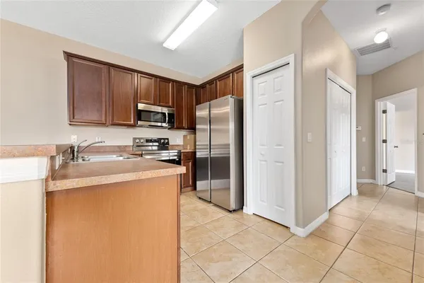 a kitchen with stainless steel appliances granite countertop a refrigerator stove top oven a sink and dishwasher