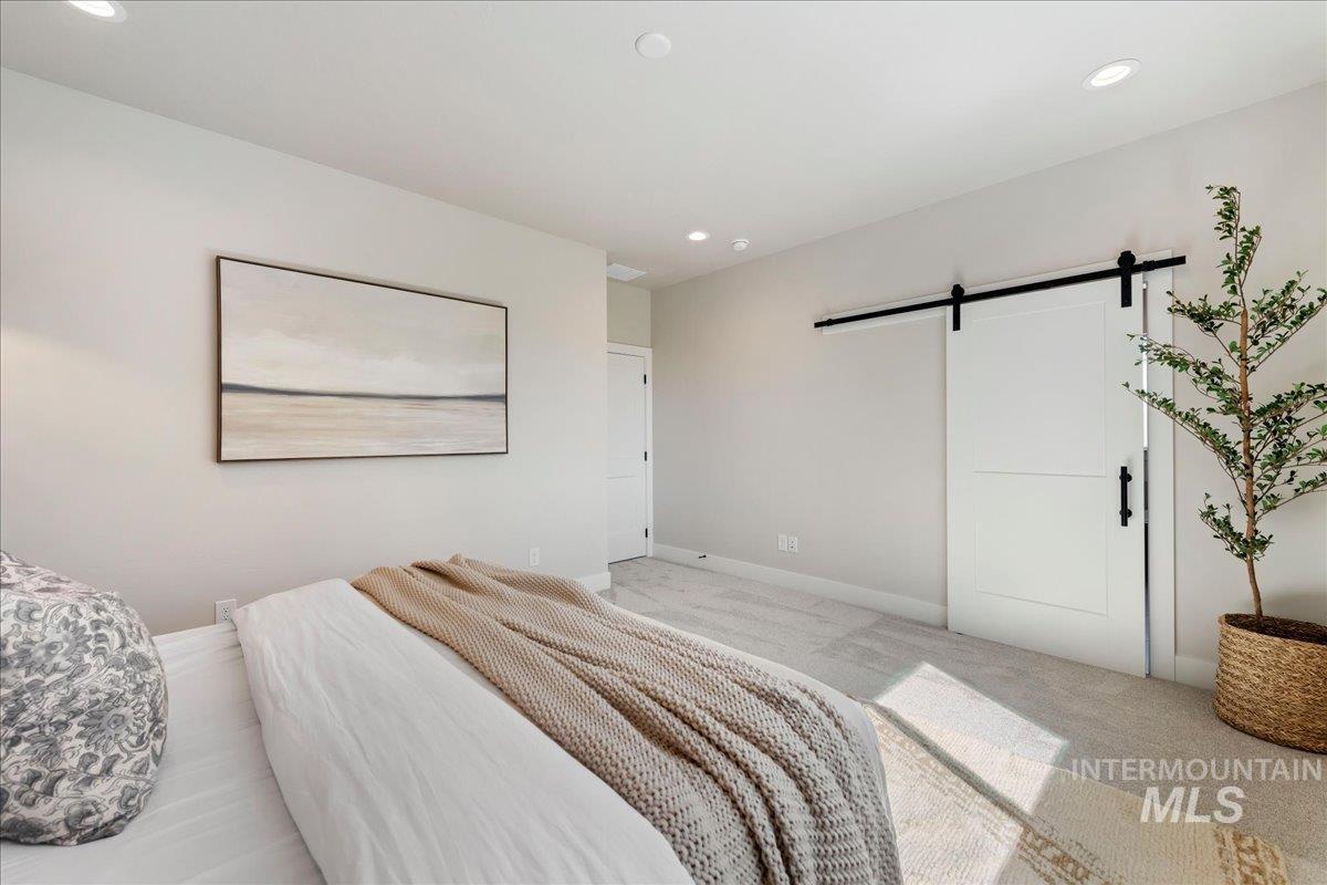 901 West Malbar Street Meridian, ID 83646 - Photo 15 of 33 Bedroom with a barn door, light colored carpet, and recessed lighting