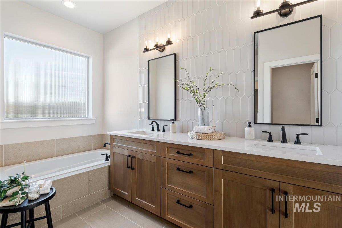 901 West Malbar Street Meridian, ID 83646 - Photo 16 of 33 Full bath with a garden tub, double vanity, light tile patterned floors, and decorative backsplash