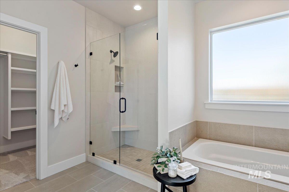901 West Malbar Street Meridian, ID 83646 - Photo 17 of 33 Full bathroom featuring a stall shower, a walk in closet, a bath, recessed lighting, and light tile patterned floors