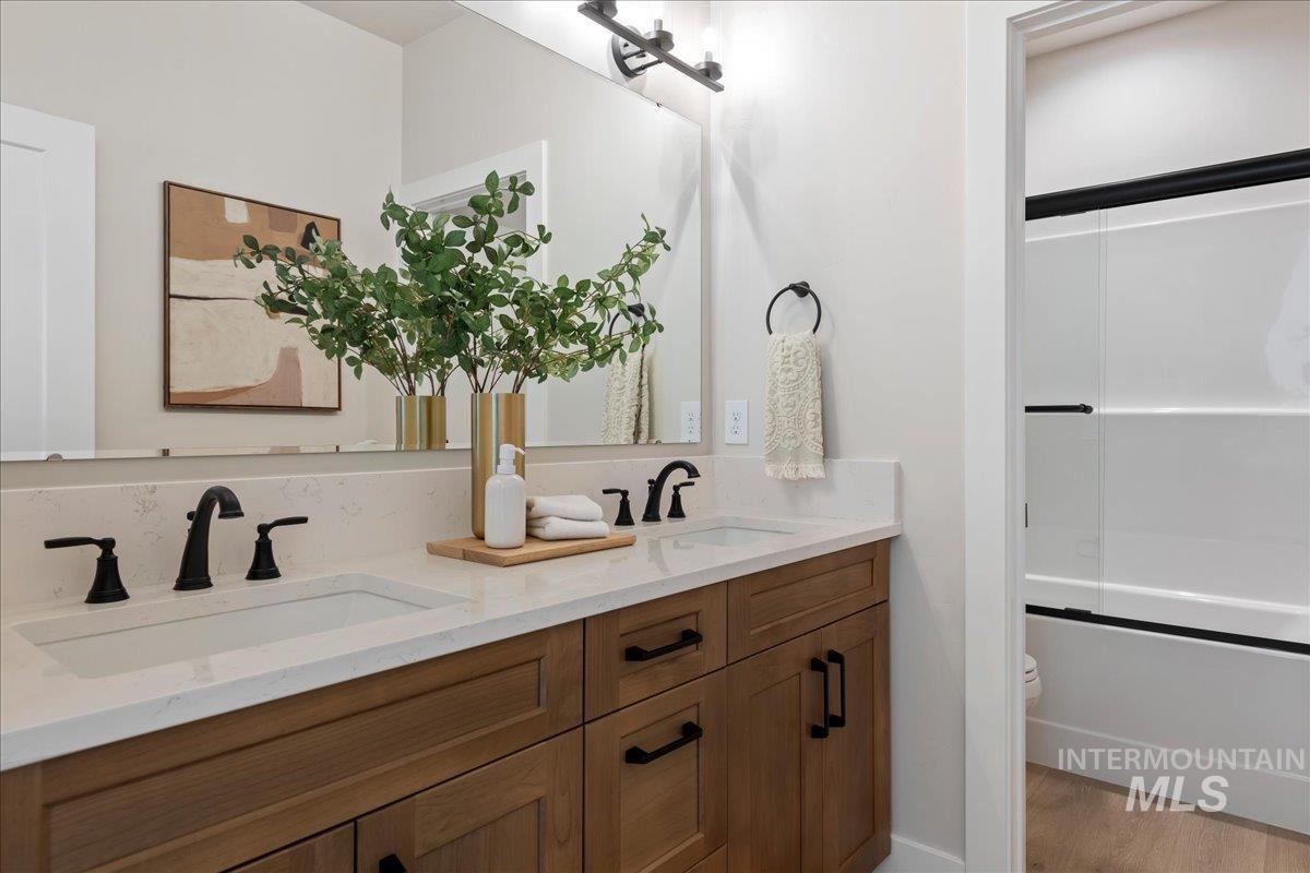 901 West Malbar Street Meridian, ID 83646 - Photo 24 of 33 Bathroom with double vanity, enclosed tub / shower combo, and light wood-style flooring