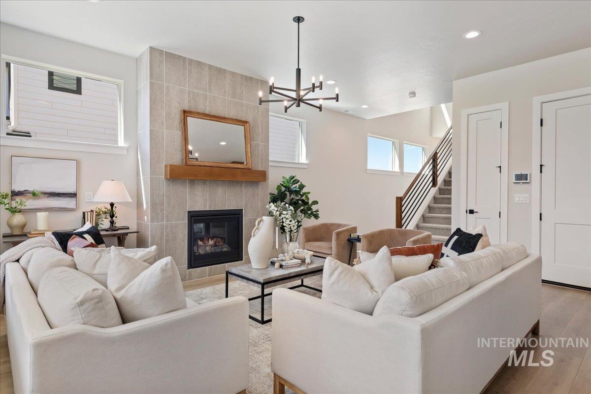 901 West Malbar Street Meridian, ID 83646 - Photo 4 of 33 Living area featuring wood finished floors, a tiled fireplace, and suspended lighting