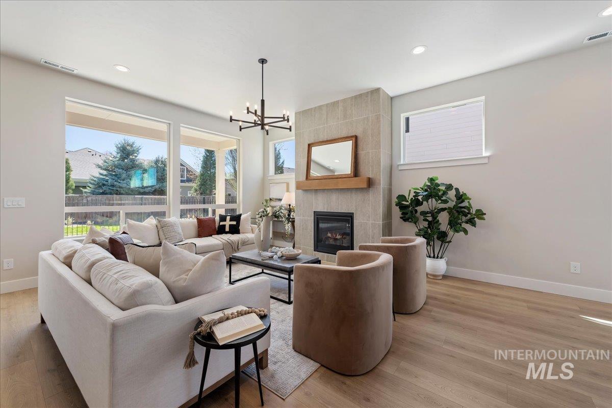 901 West Malbar Street Meridian, ID 83646 - Photo 5 of 33 Living area featuring hanging lights, light wood finished floors, a fireplace, and plenty of natural light