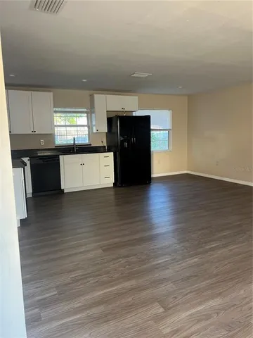 a kitchen with stainless steel appliances wooden cabinets and a wooden floor