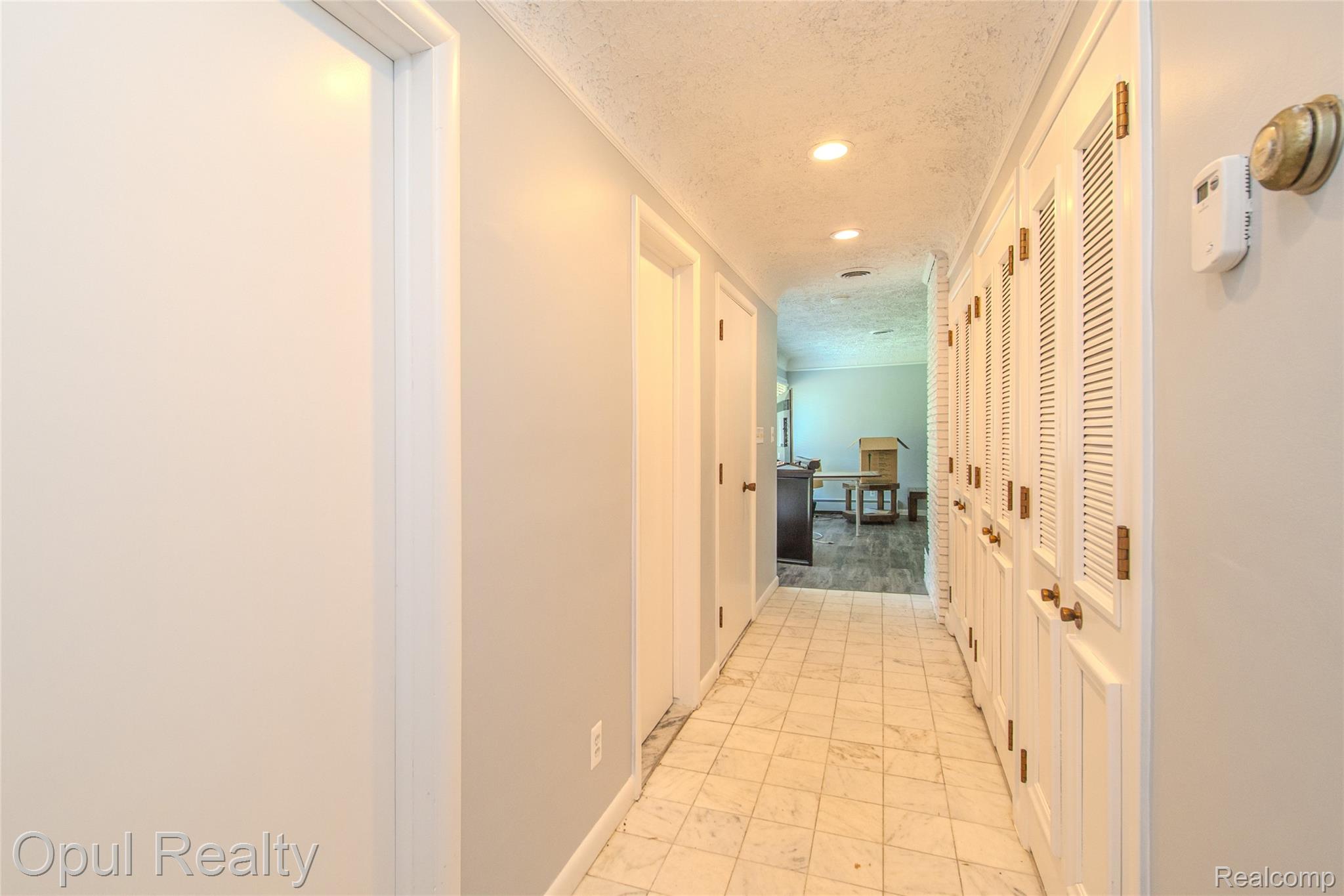 6455 Norham Road Bloomfield Hills, MI 48301 - Photo 26 of 93 Hallway featuring tiled flooring, recessed lighting, white louvered closet doors with brass hardware, and painted walls