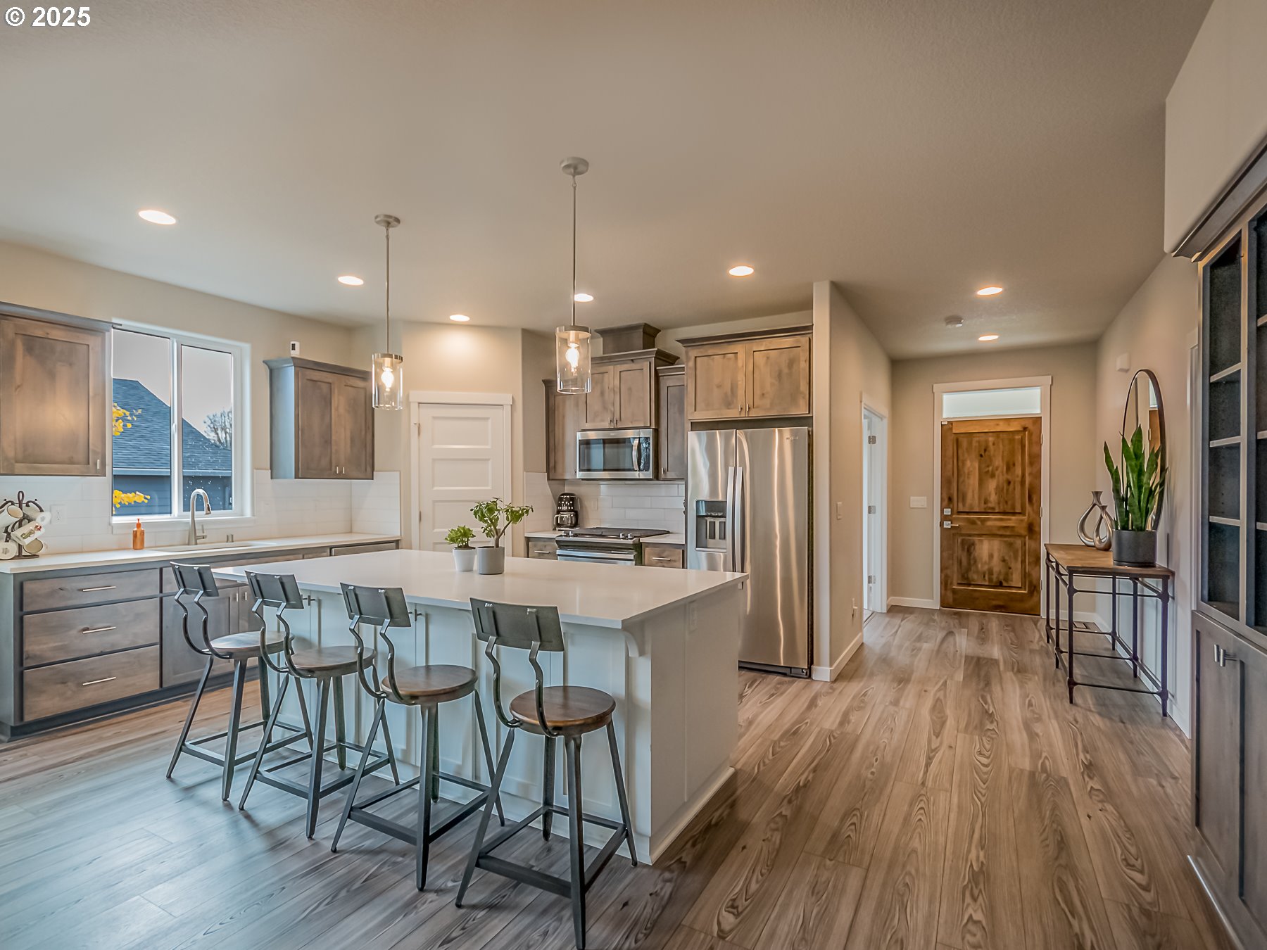 2116 North 3rd Way Ridgefield, WA 98642 - Photo 15 of 40 a kitchen with stainless steel appliances a dining table chairs stove refrigerator and wooden floor