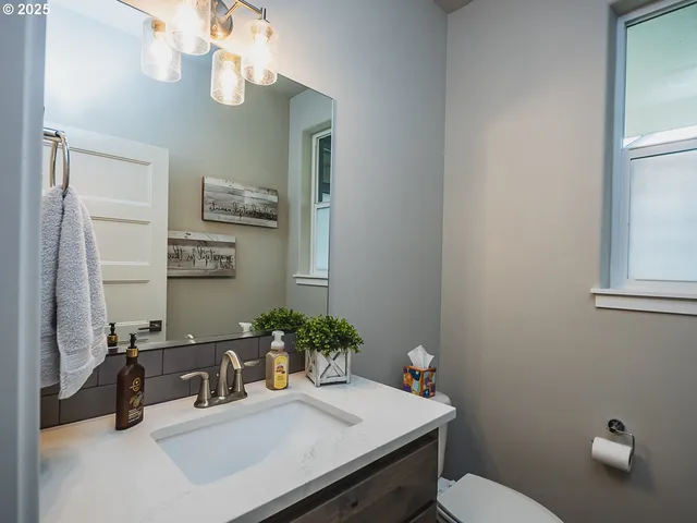 a bathroom with a sink a toilet and mirror