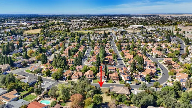 an aerial view of residential houses with outdoor space and trees