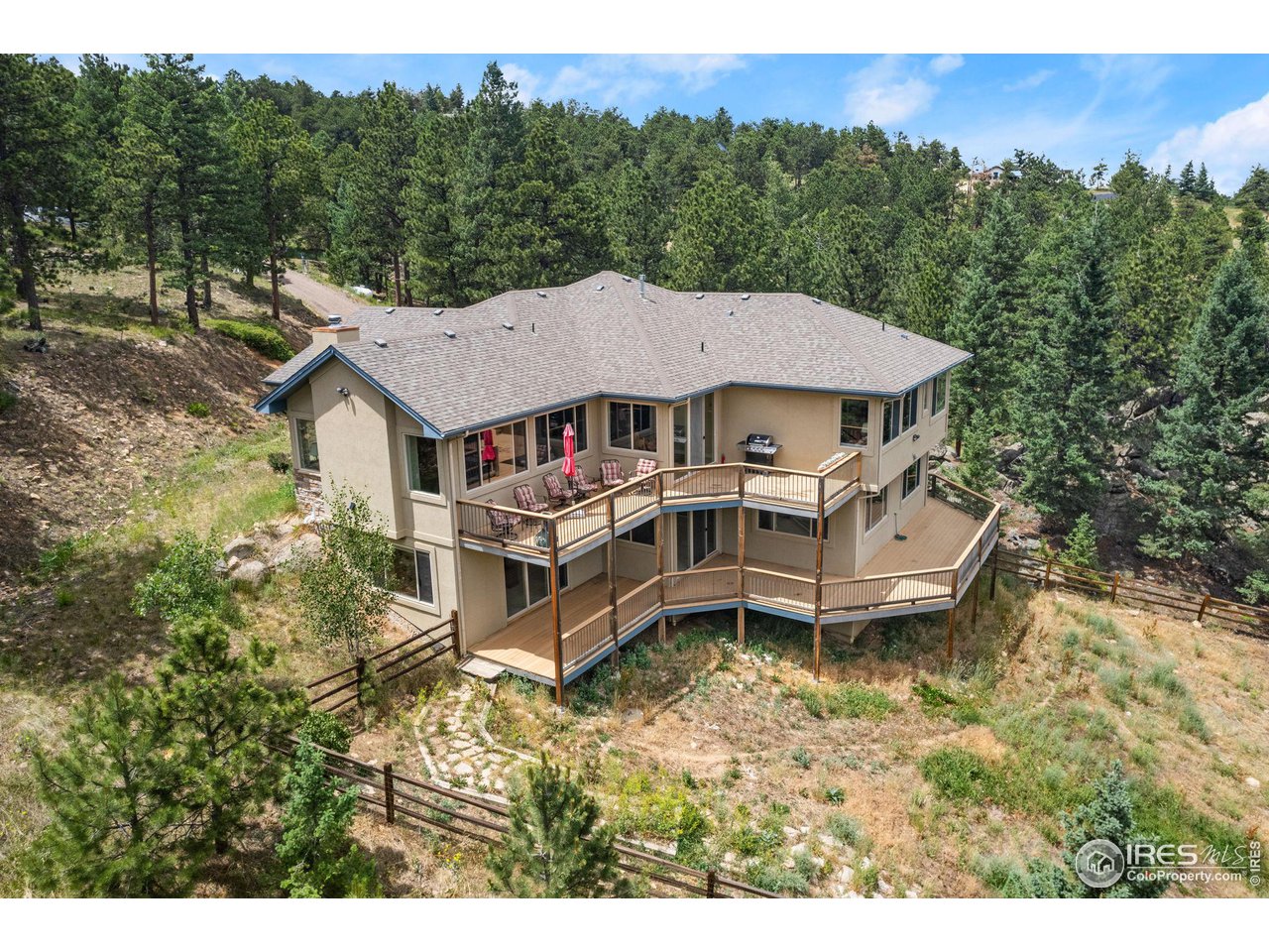 a aerial view of a house with a big yard and large trees