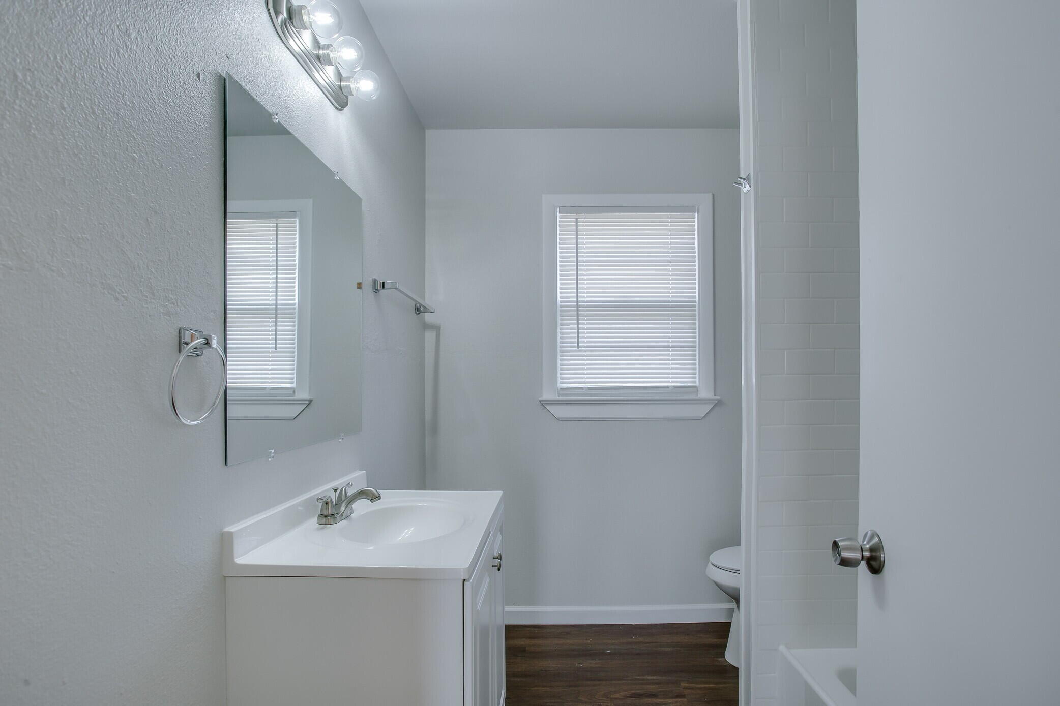 4315 32nd Street Lubbock, TX 79410 - Photo 11 of 15 a bathroom with a sink a toilet and mirror