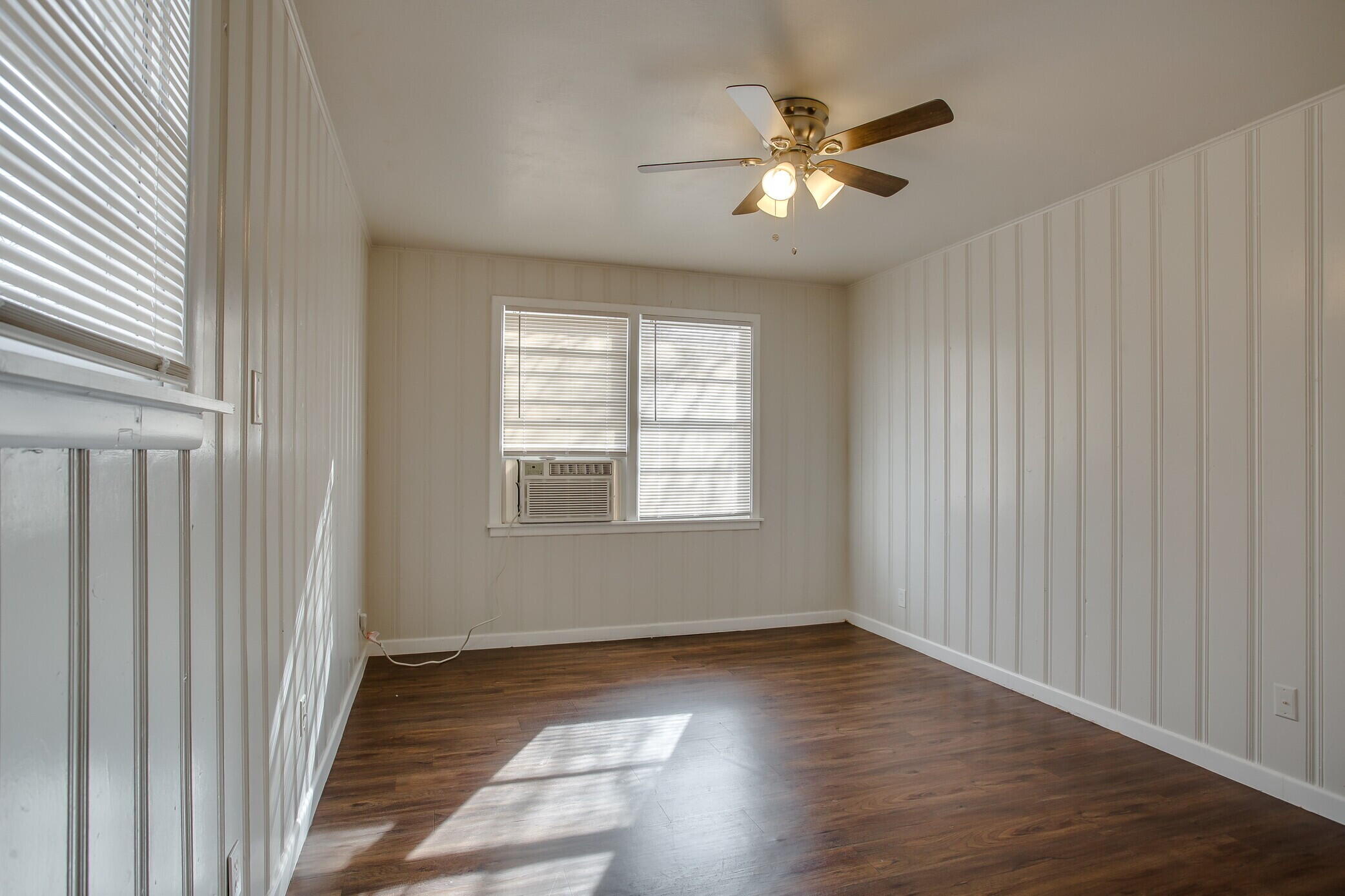 4315 32nd Street Lubbock, TX 79410 - Photo 12 of 15 a view of an empty room with wooden floor and a window