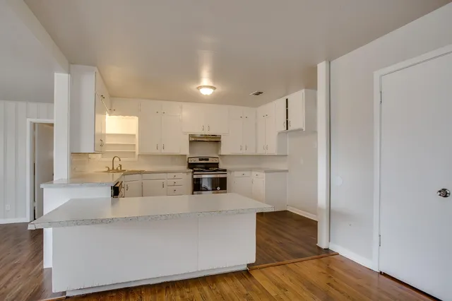 a kitchen with stainless steel appliances a refrigerator and a stove top oven
