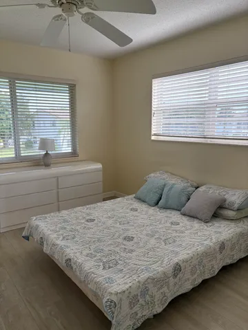 a view of a bedroom with wooden floor and ceiling fan