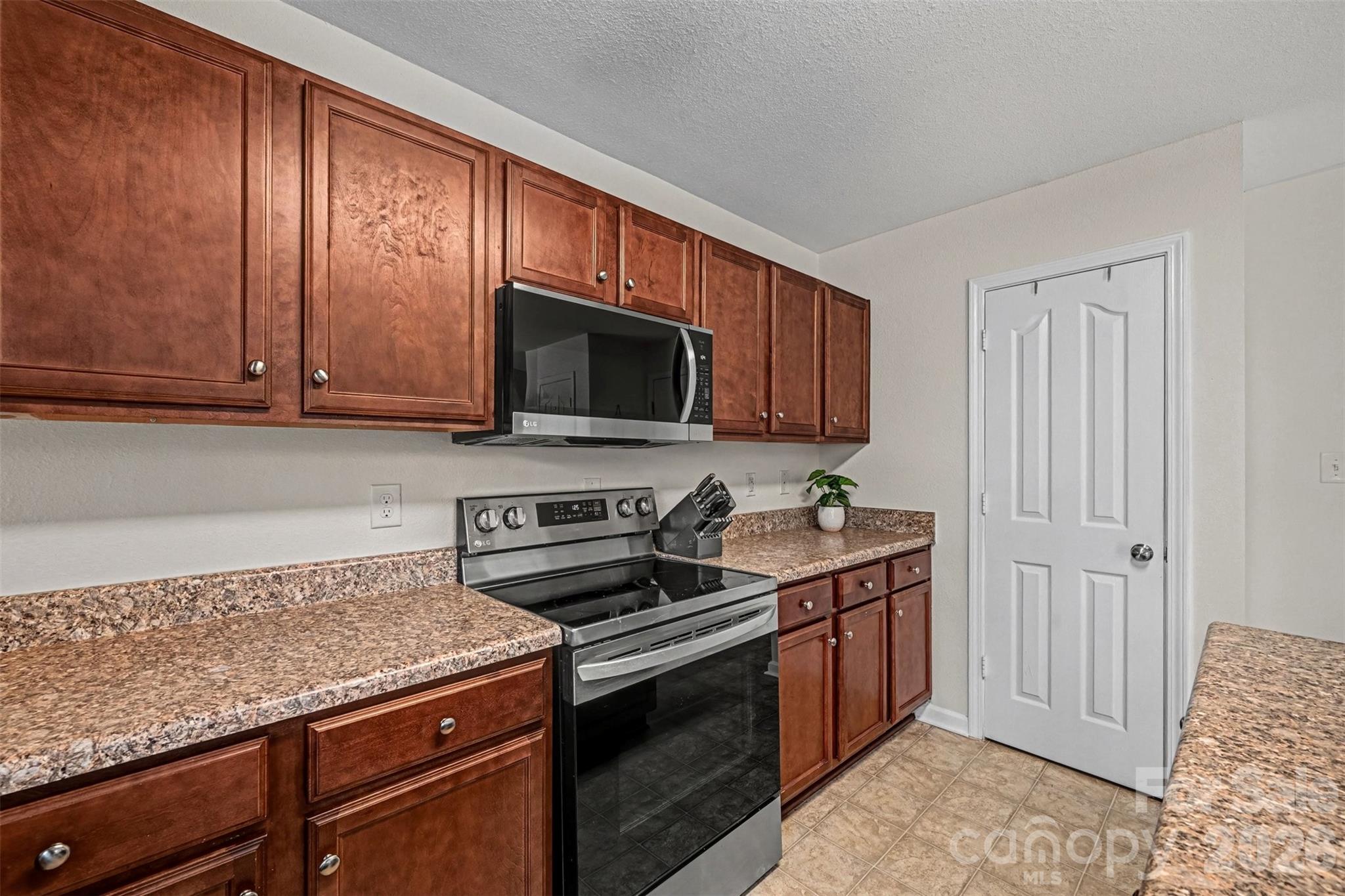 4804 Manchineel Lane Monroe, NC 28110 - Photo 9 of 28 a kitchen with stainless steel appliances granite countertop a stove a sink and a microwave