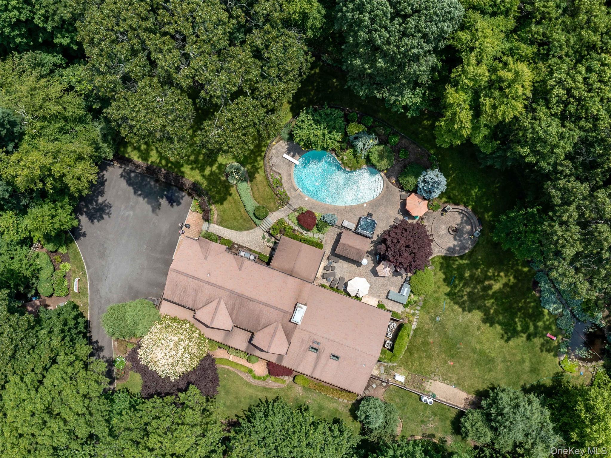 an aerial view of a house with a yard and large trees