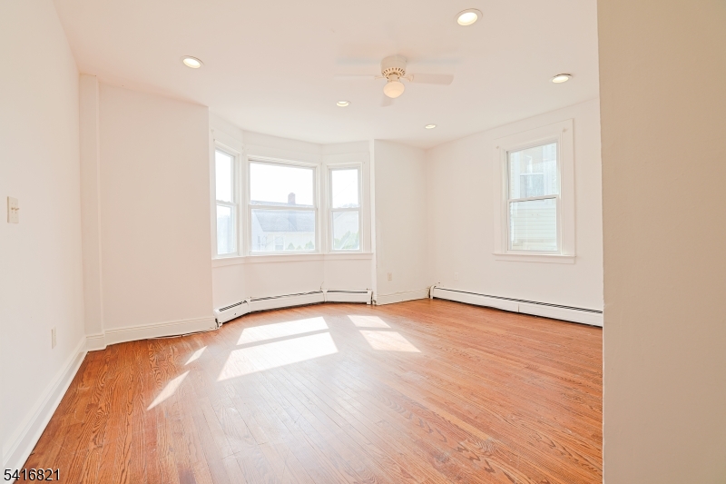58 Prospect Street, Unit A Dover, NJ 07801 - Photo 2 of 10 an empty room with wooden floor and windows