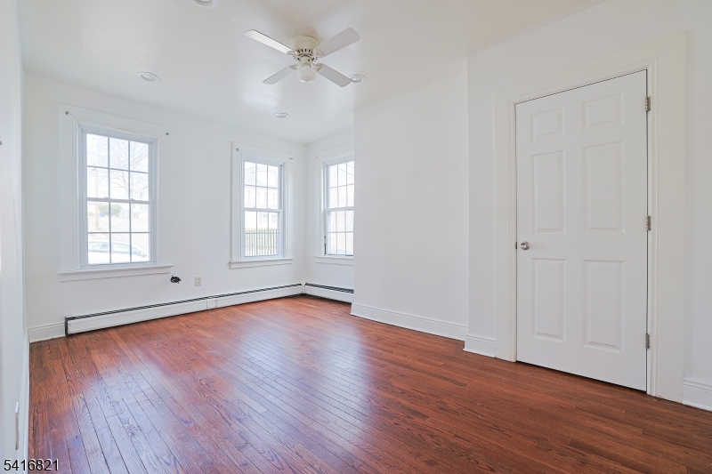 58 Prospect Street, Unit A Dover, NJ 07801 - Photo 5 of 10 an empty room with wooden floor ceiling fan and windows