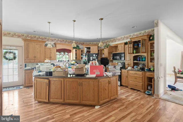 a kitchen filled with stainless steel appliances kitchen island granite countertop a stove and a wooden floors