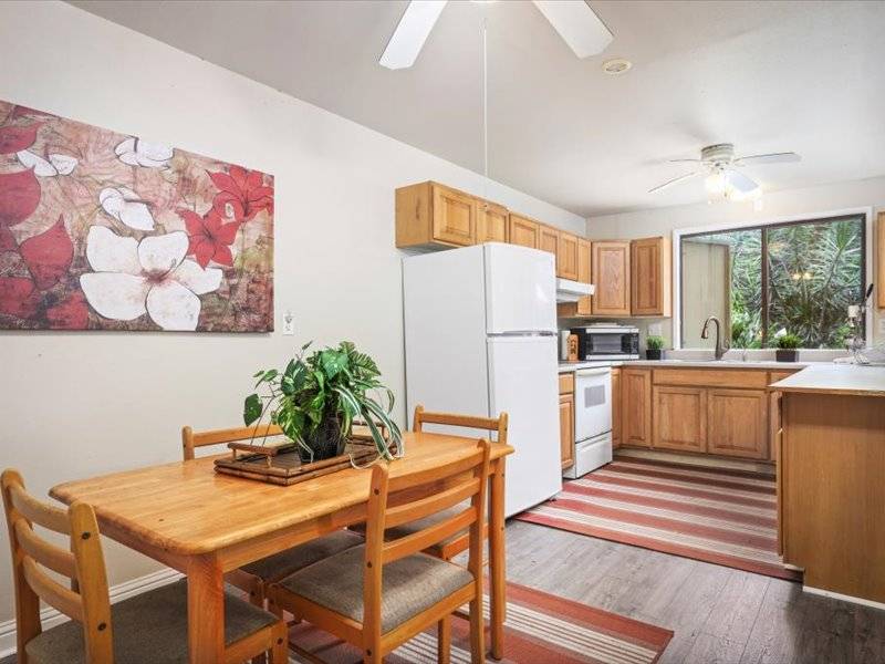 84-5193 Hawaiʻi Belt Road Captain Cook, HI 96704 - Photo 17 of 30 a kitchen with stainless steel appliances kitchen island granite countertop a refrigerator and a stove top oven