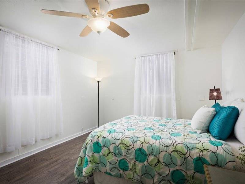 84-5193 Hawaiʻi Belt Road Captain Cook, HI 96704 - Photo 18 of 30 a bedroom with a bed and a chandelier