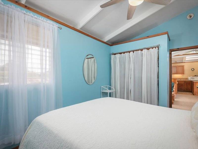 84-5193 Hawaiʻi Belt Road Captain Cook, HI 96704 - Photo 27 of 30 a bedroom with a large bed and a large window