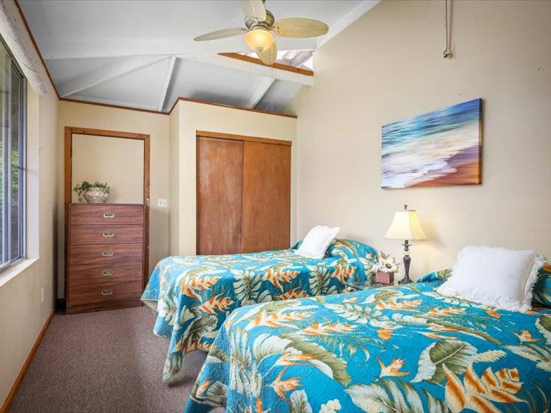 84-5193 Hawaiʻi Belt Road Captain Cook, HI 96704 - Photo 29 of 30 a bedroom with a bed and a painting on the wall