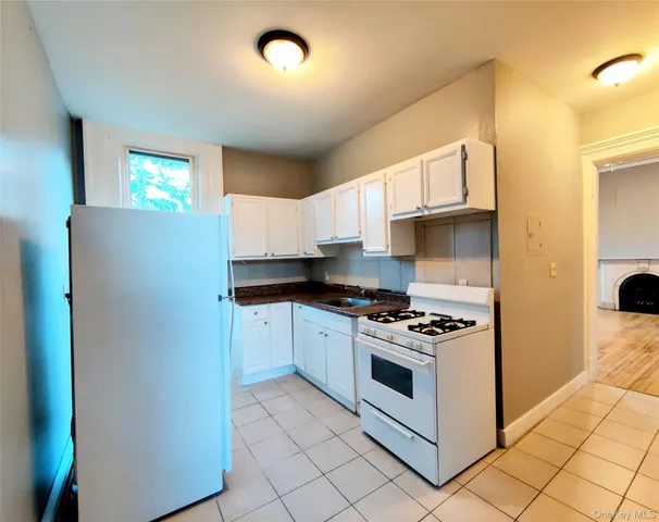a kitchen with granite countertop white cabinets and white appliances