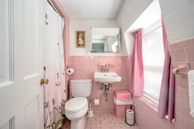 a bathroom with a sink toilet and a mirror