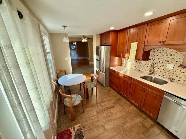 a kitchen with stainless steel appliances kitchen island granite countertop a refrigerator and a wooden cabinets